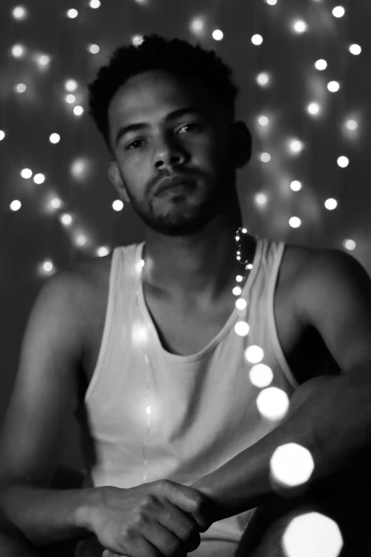 a man wearing a tank top sitting on a chair