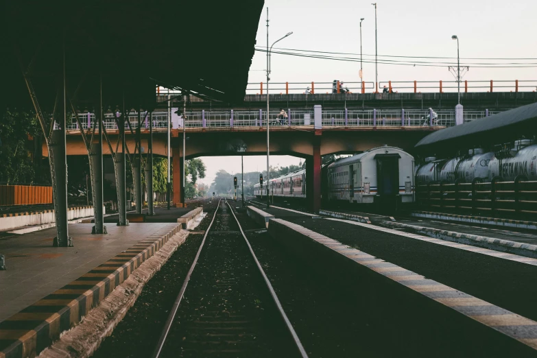 train tracks running through an empty station with an underpass