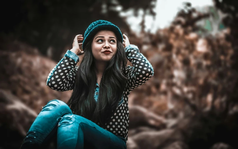 a woman wearing a polka dot sweater and a hat