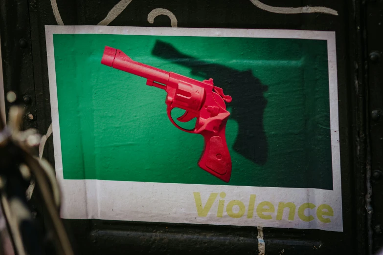a red plastic gun on top of green background