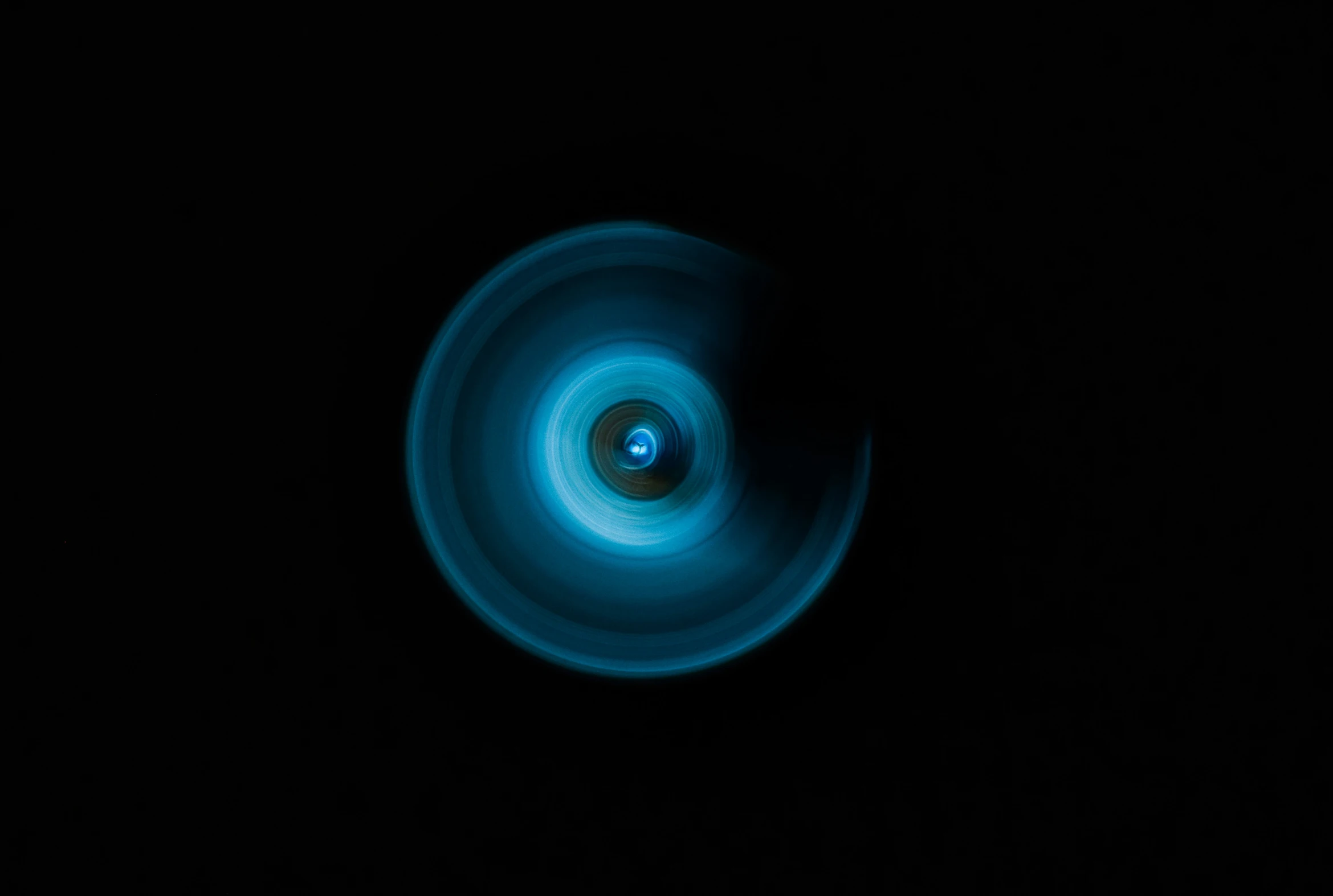 a blue object floating through the dark space