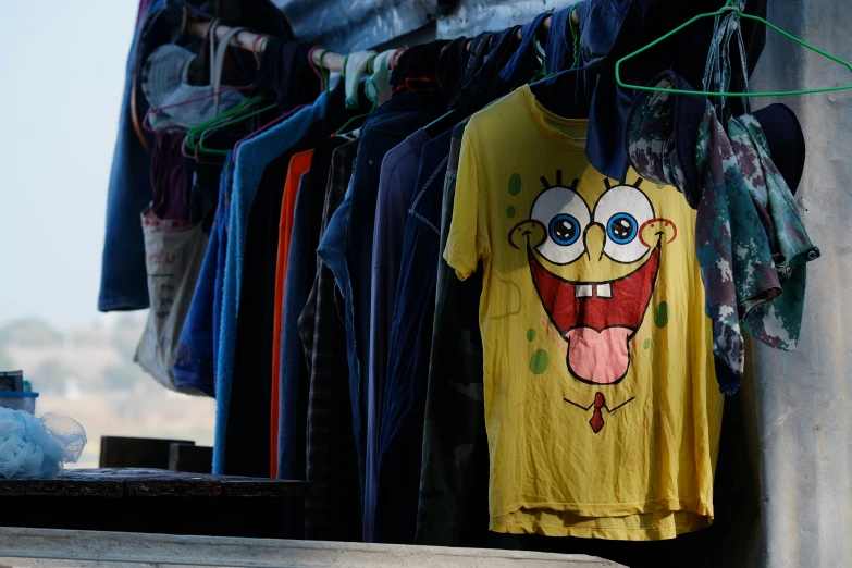 a display of shirts with cartoon face shirts hanging up