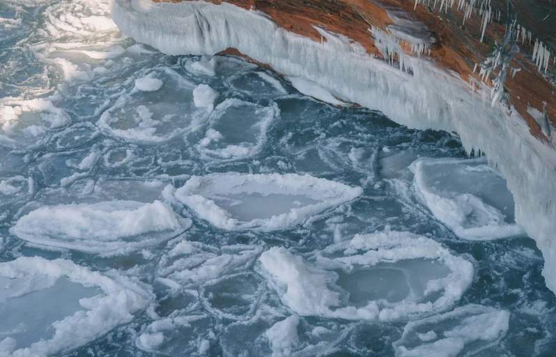 ice covered water with icicles on the edge