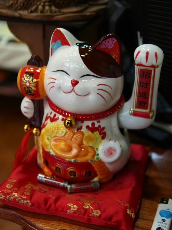 a figurine sits atop a red blanket on a table