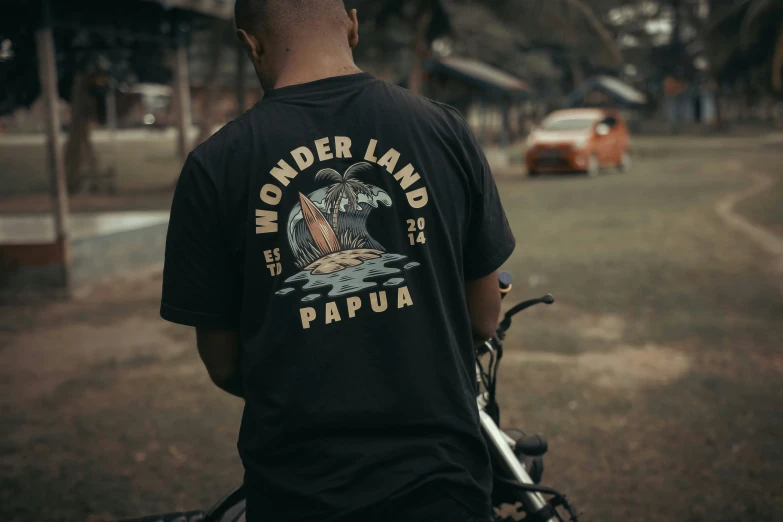 a black man in a tee shirt riding a bike