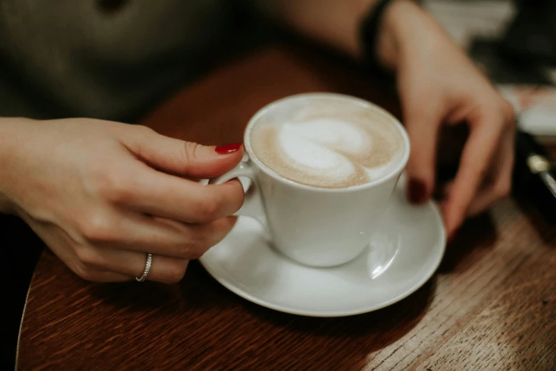 a woman holding onto a cup of coffee