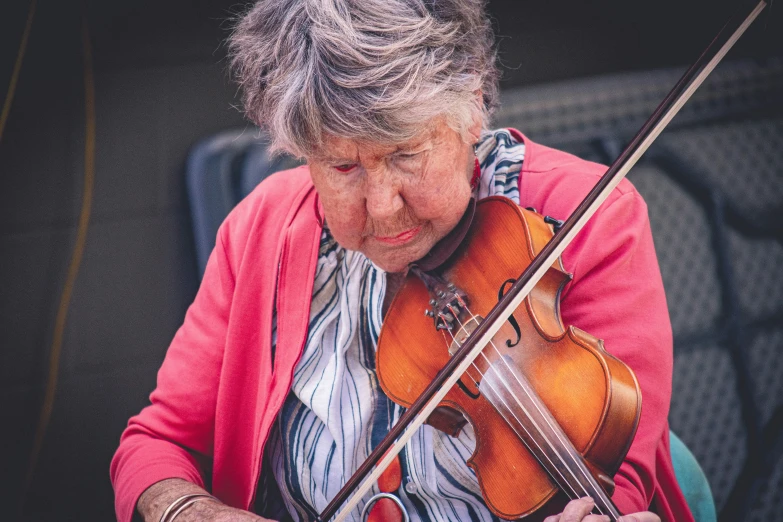 a close up of a woman playing violin