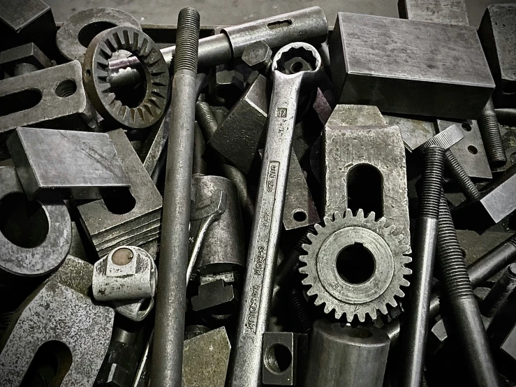 a pile of assorted metal parts and a wrench