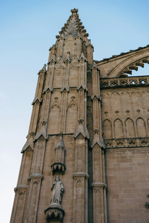 the side of a building with an arch and a statue