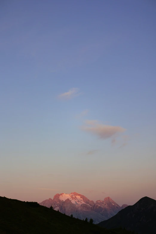 silhouette of a man holding a red frisbee while standing on a hill