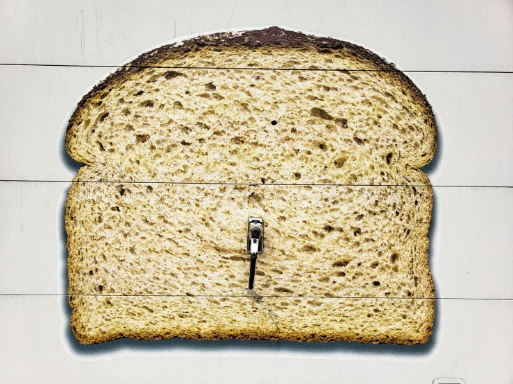 a picture with several holes in it, and there is a slice of bread on the wall