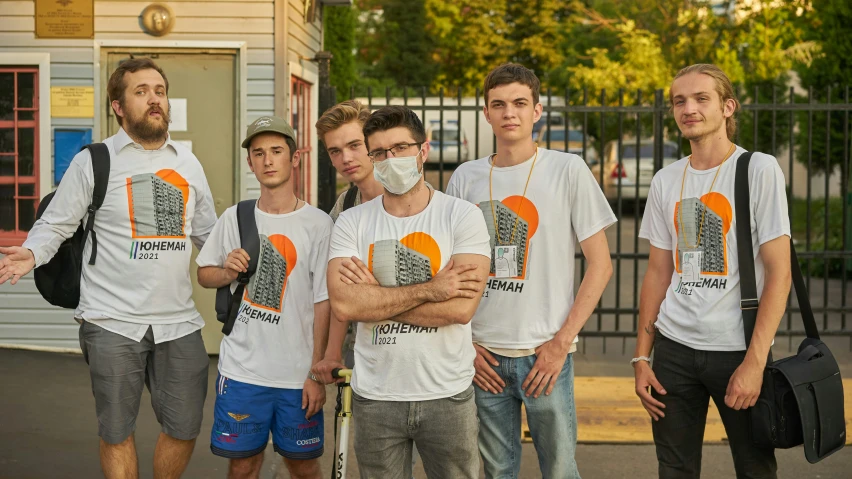 a group of men standing next to each other in front of a gate