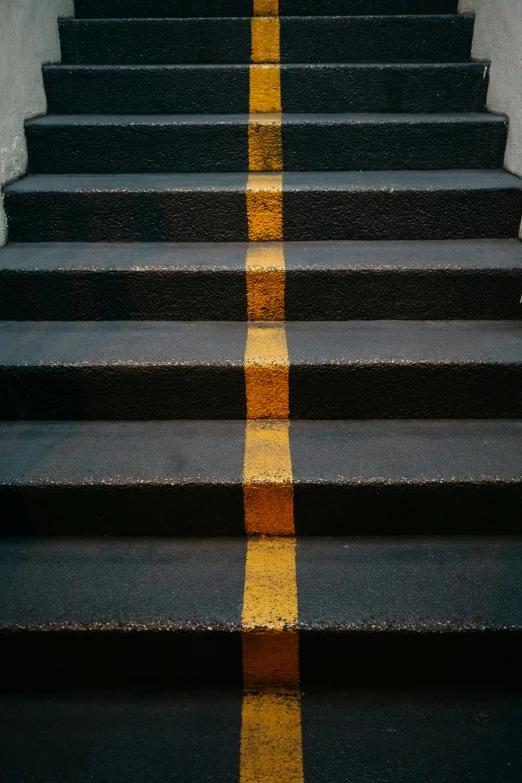 a yellow stripe on some steps leading to an open stairway