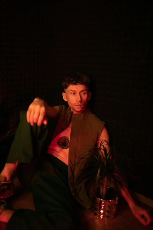 a man sitting on a stool holding a plant in his hand