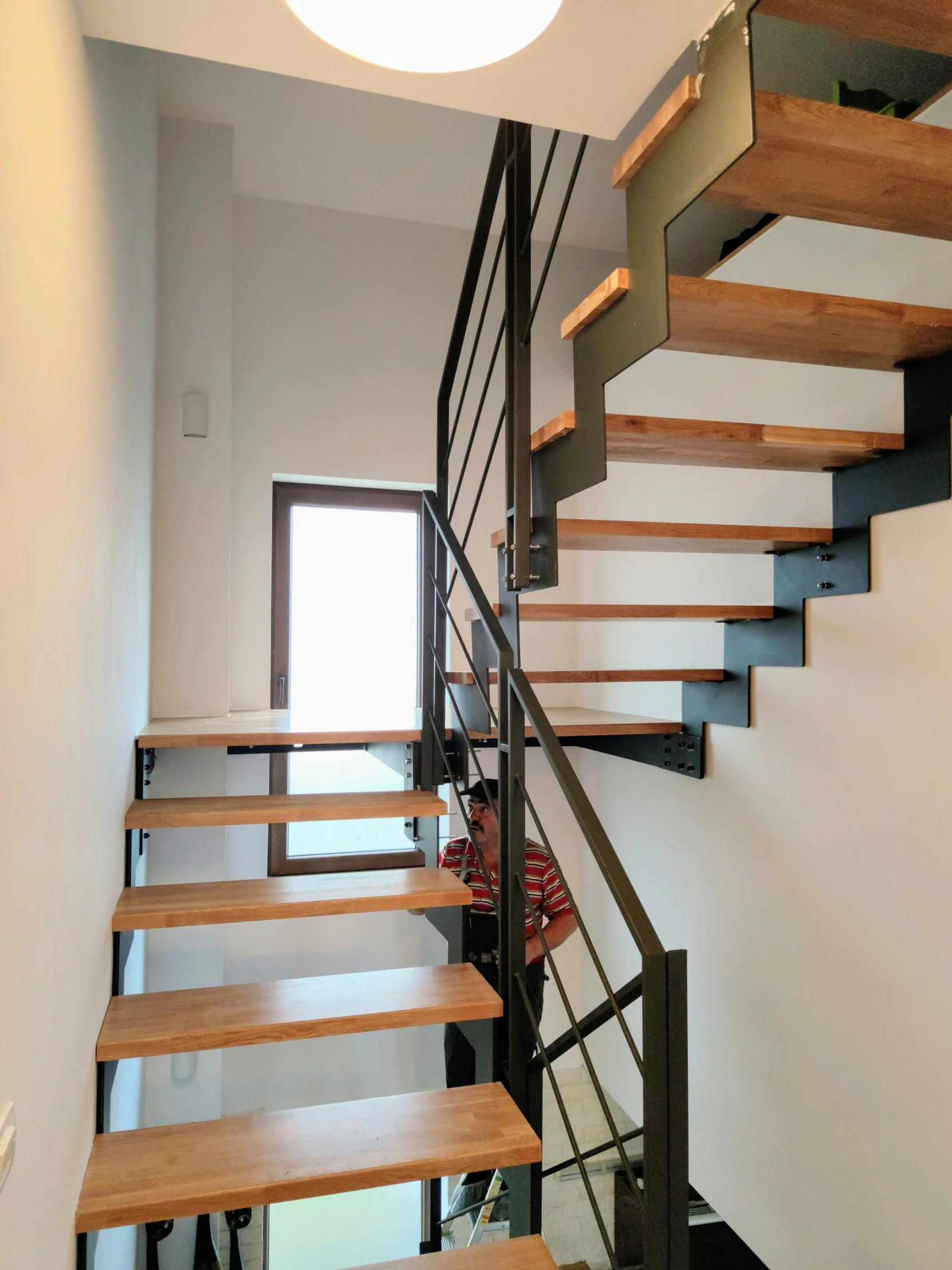 a staircase with wood balconies and black railings