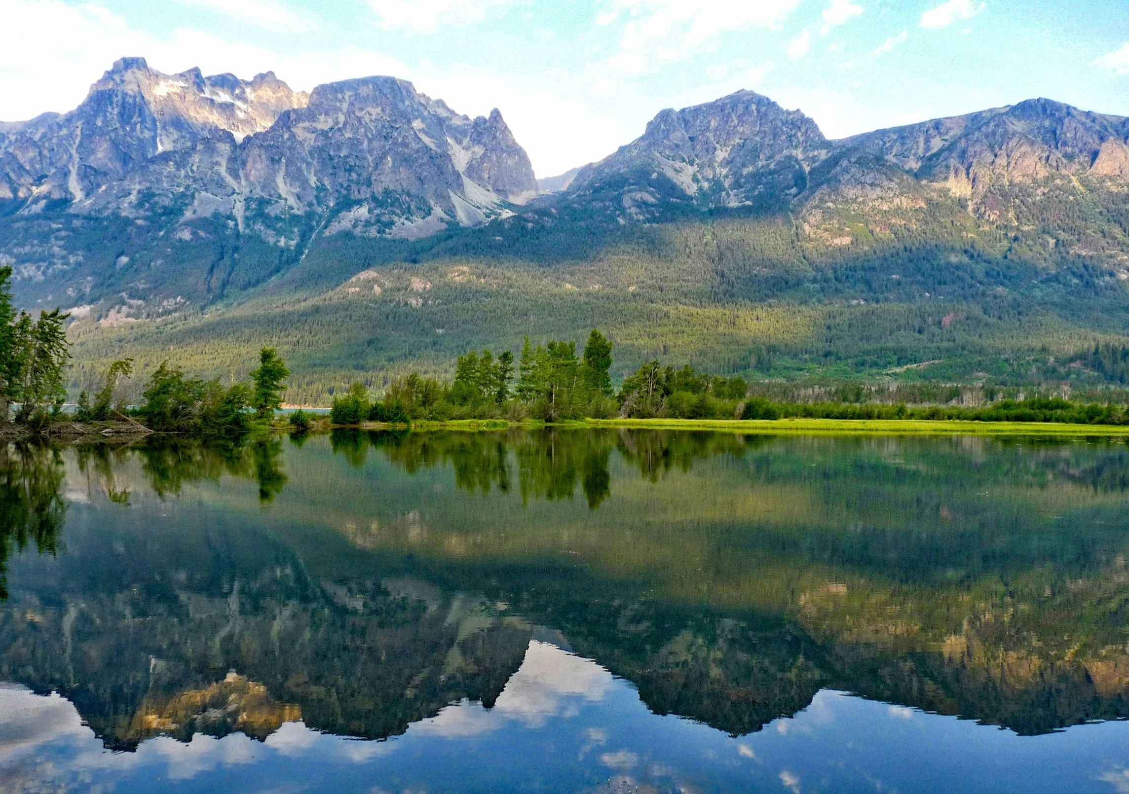 some mountains reflecting off of a large body of water