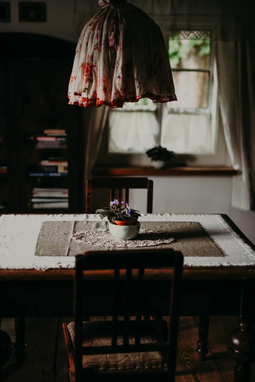 a table with a bowl and pot on it near a window