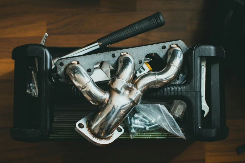 several pipes and tools sit inside an old briefcase