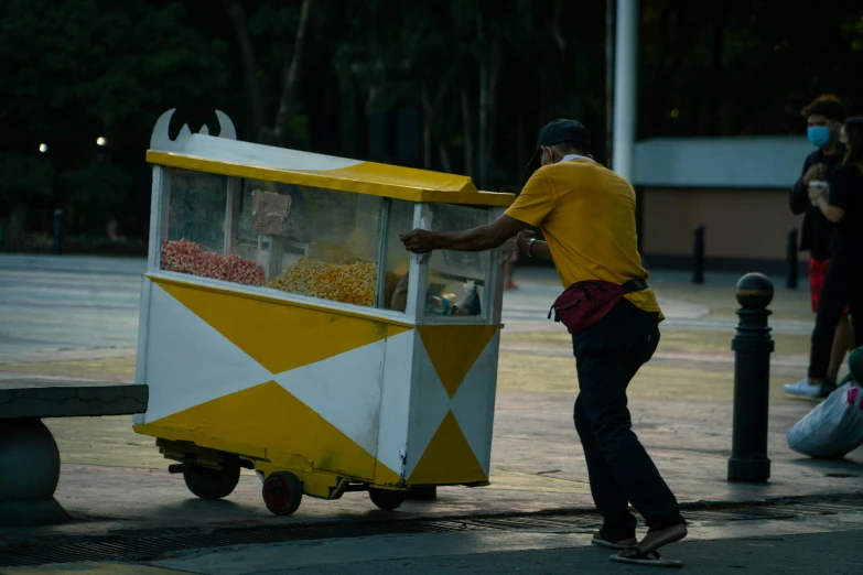 a man stands at an old fashioned popcorn machine