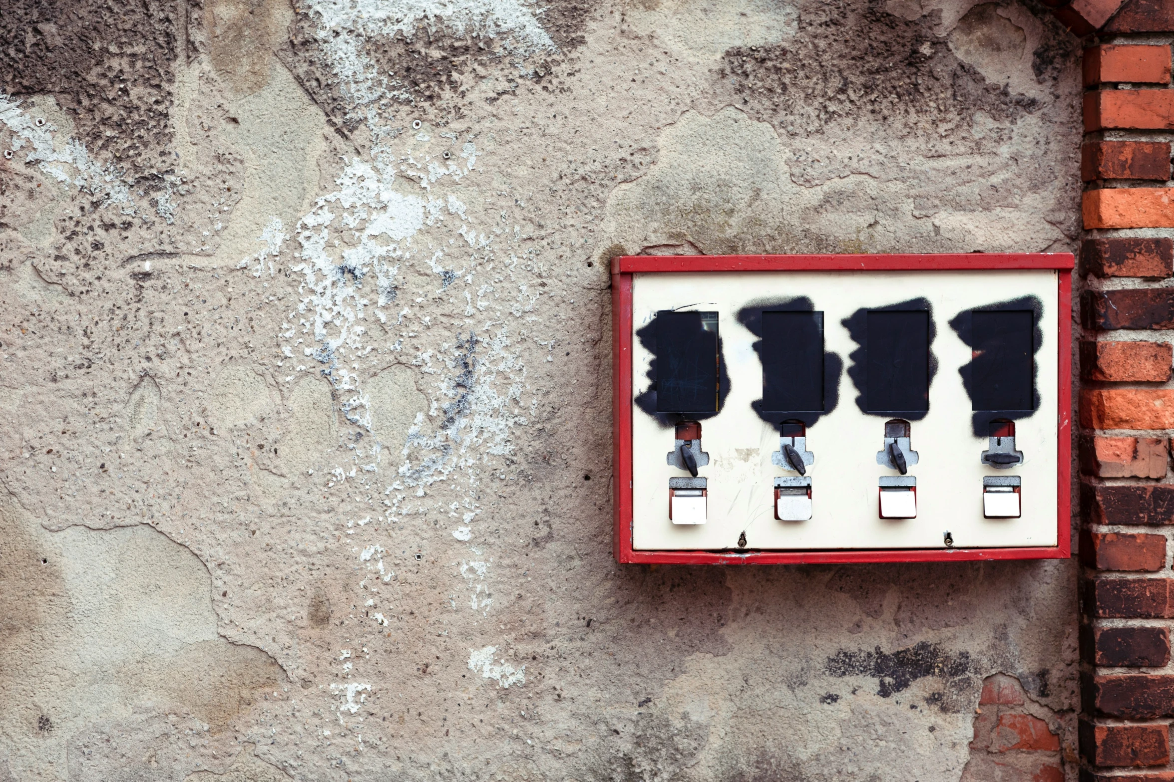 five paint rollers mounted to a brick wall