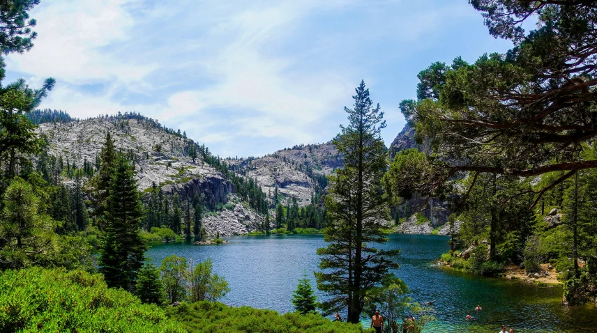 a body of water surrounded by trees and mountain side