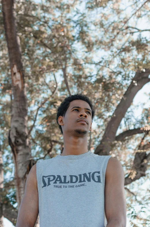 a man in a tank top with trees in the background