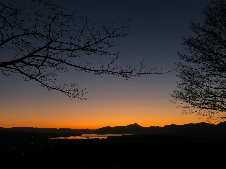 a po of the sun setting behind some trees