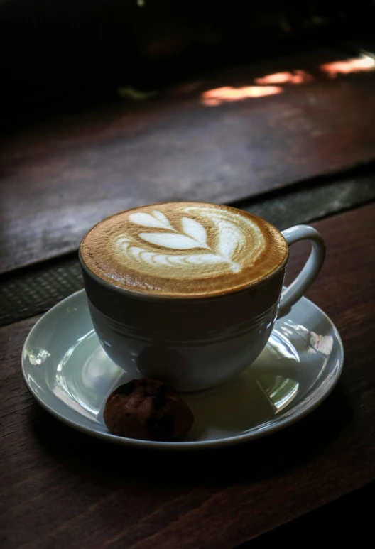 a cappuccino is sitting on a saucer on a table