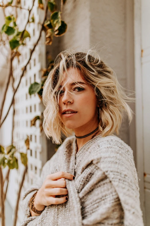 a woman in a white sweater posing for a po