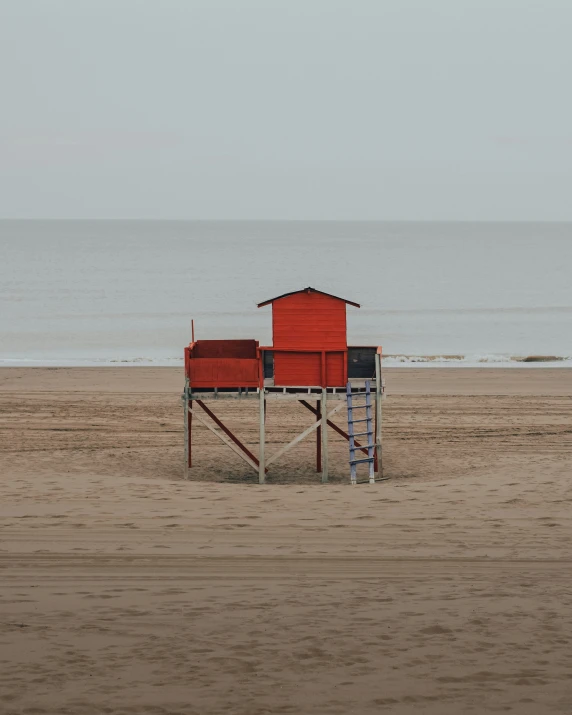a lifeguard chair sitting on the beach in front of the ocean
