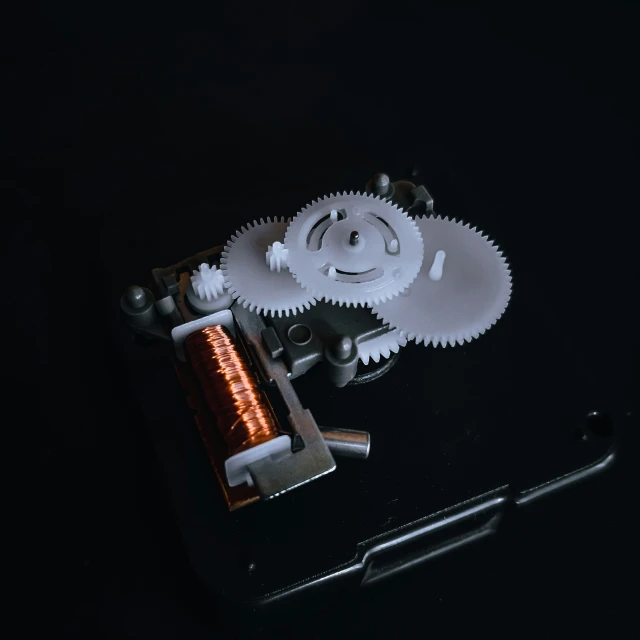 a piece of metal, gear and a flashlight on top of a table