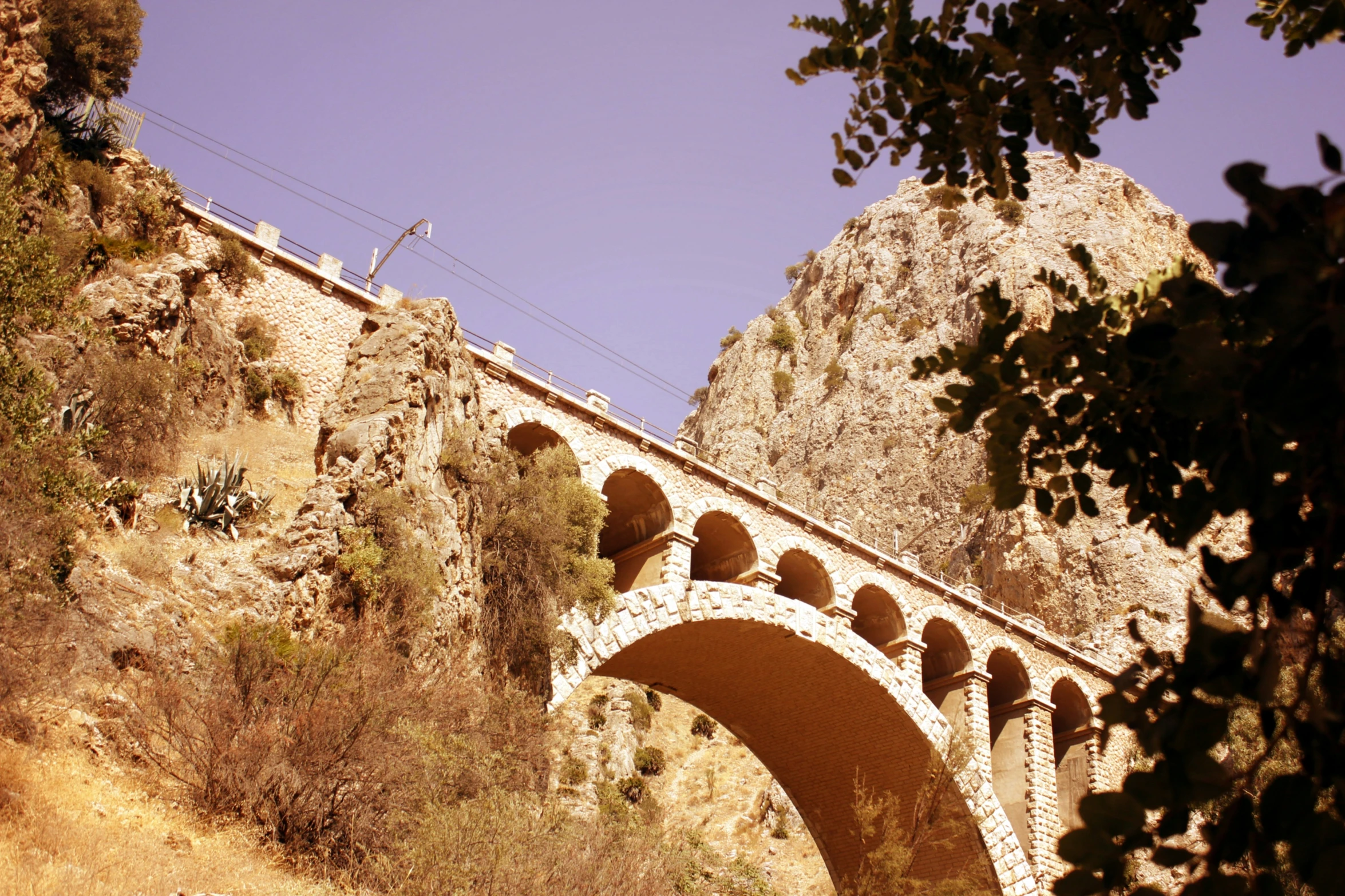 an arch with arches stands near a stone wall