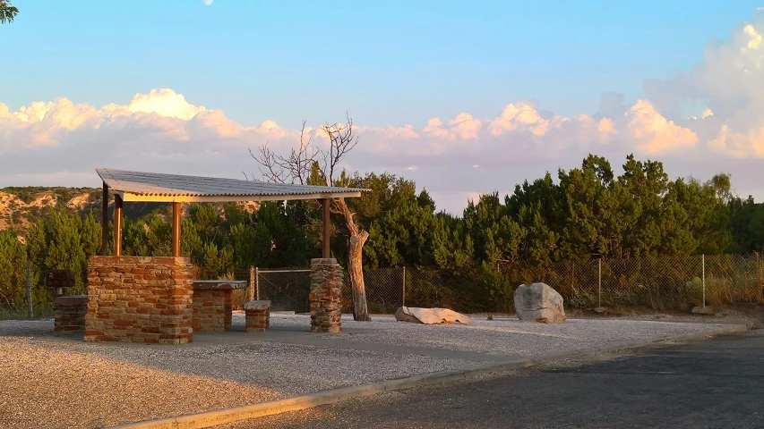 a gravel lot with a fence around it and benches