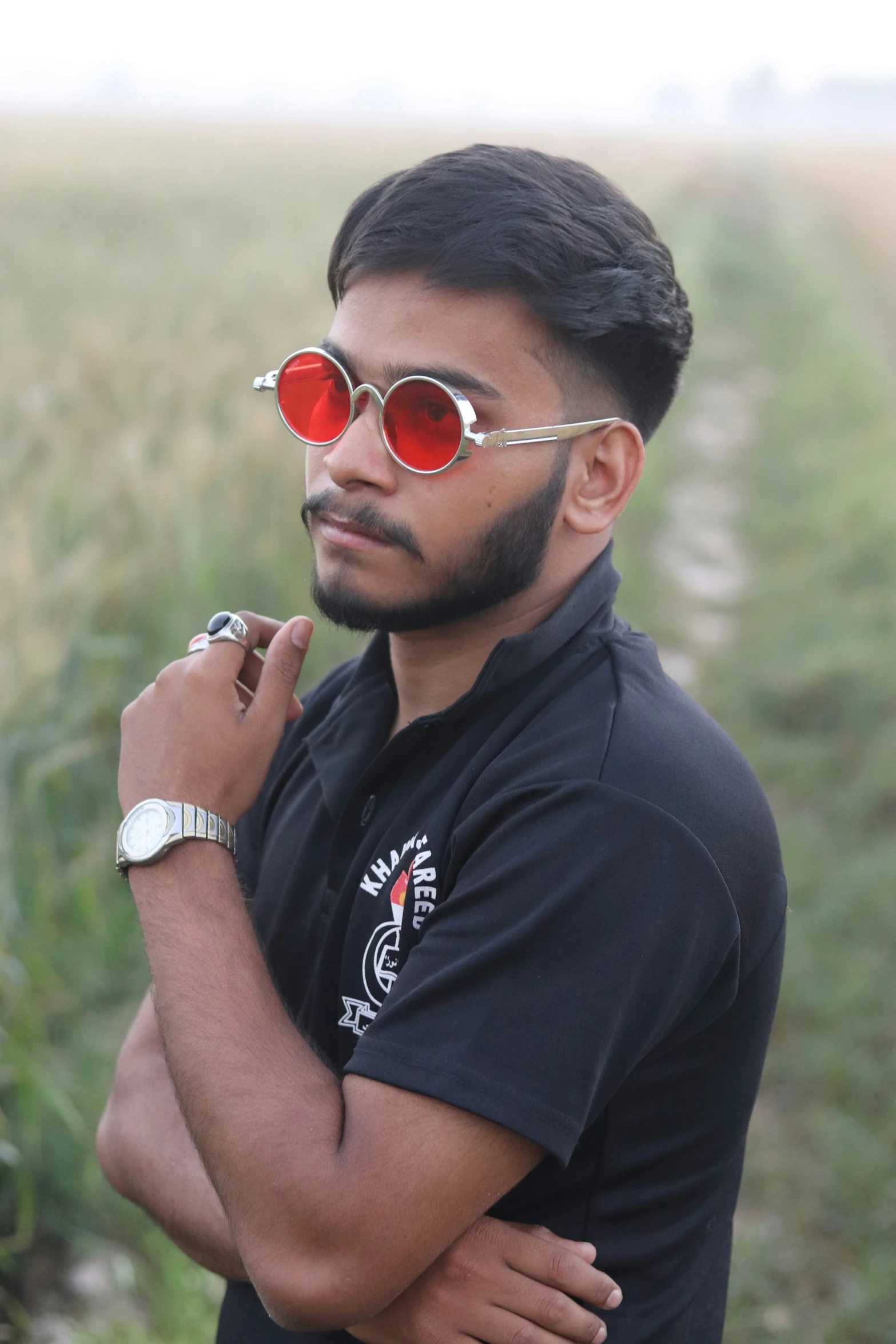 man wearing sunglasses in an open field with crops