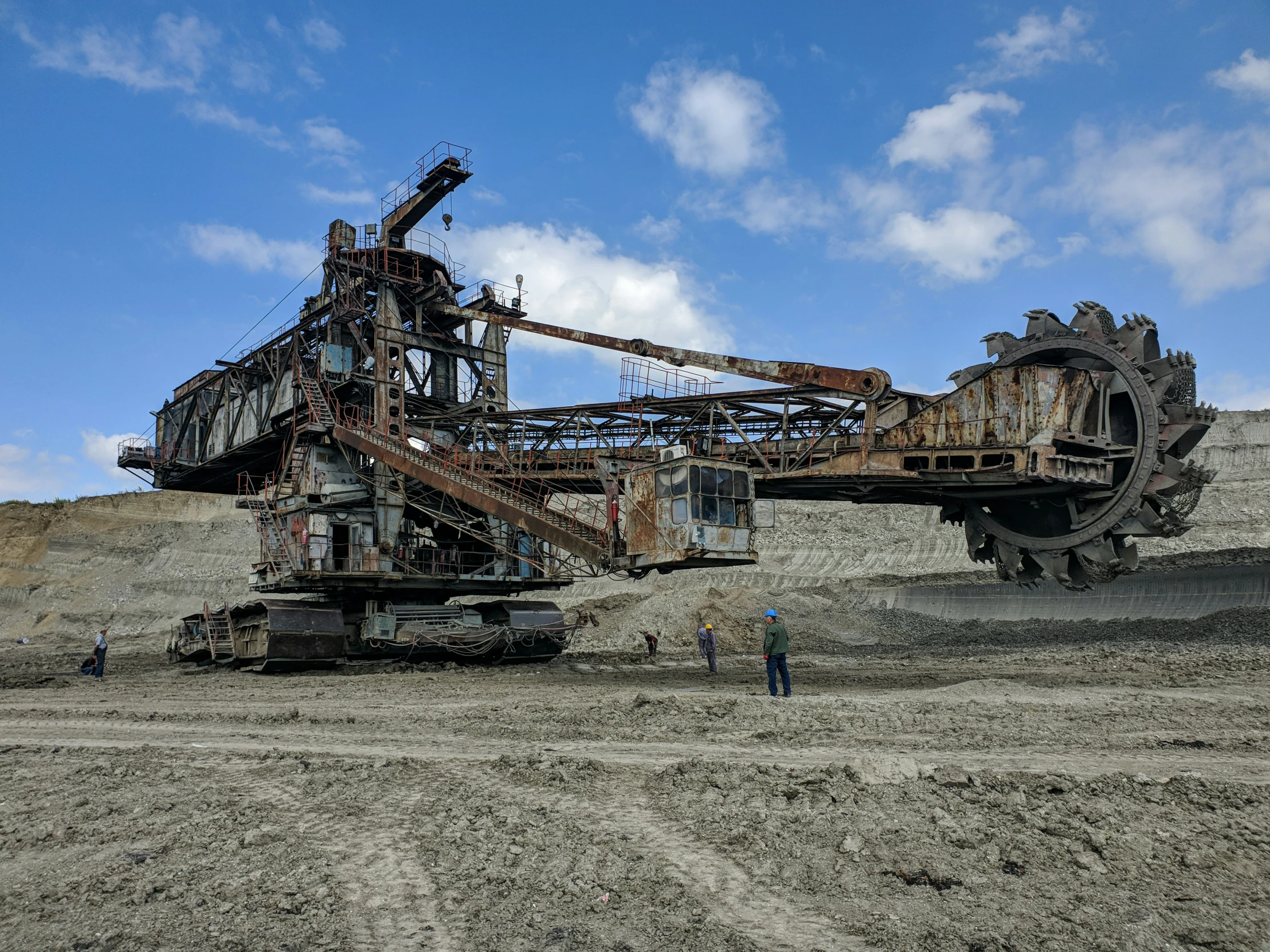 two large machinery trucks are in a dirt field