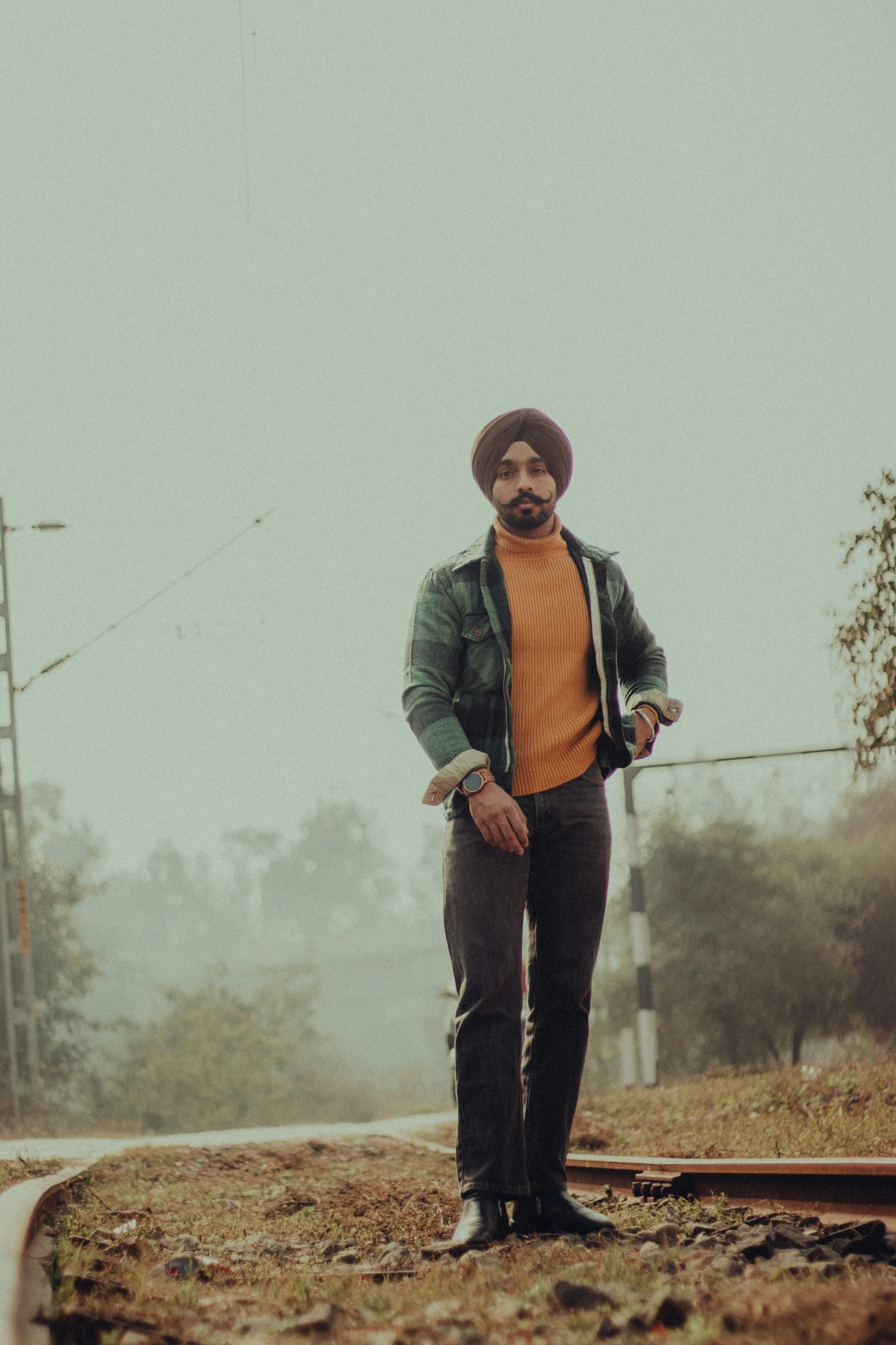 a man standing next to a rail on the tracks