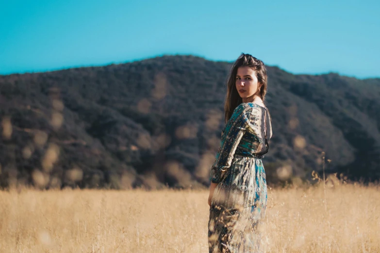  standing in tall grass next to mountains