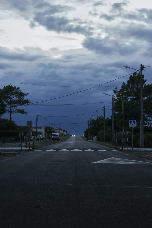 empty street at night with cars on the road and lights from stoplights