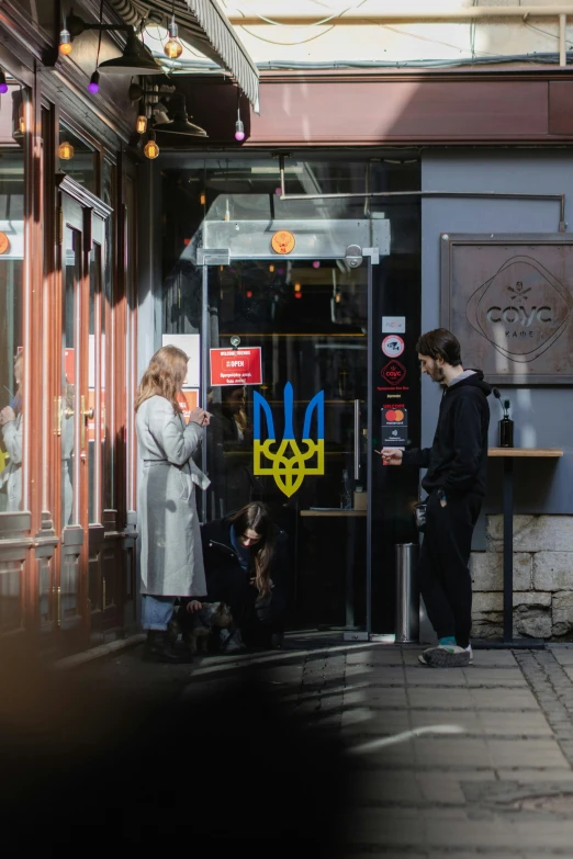 three people standing on a sidewalk in front of a building