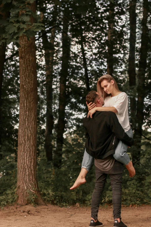 two people that are hugging in the woods