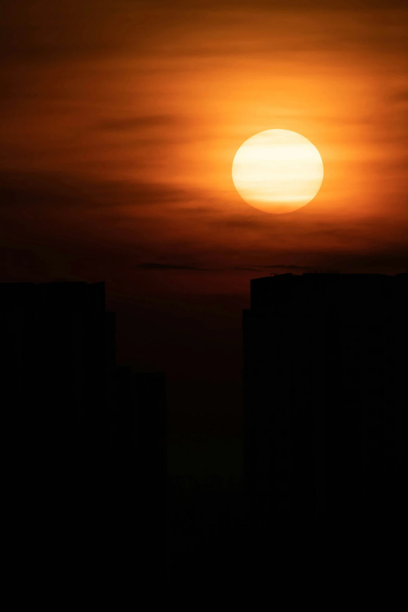 the sun shining in the sky over some buildings