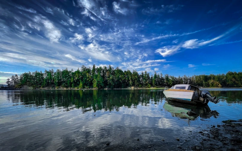 the water is calm and clear with a small boat in it