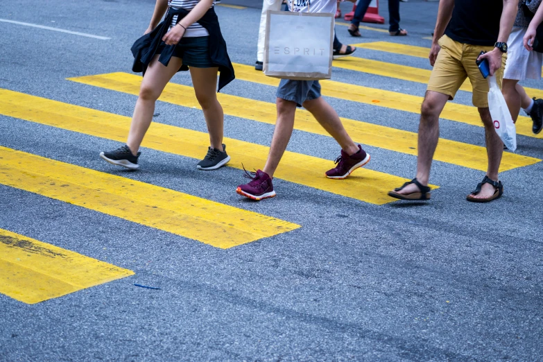 pedestrians crossing a city street at a crosswalk