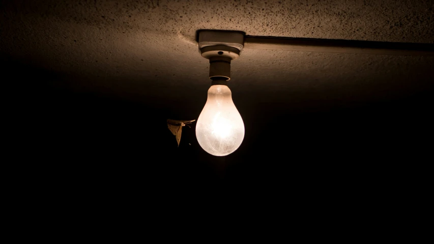 a light bulb hanging from the ceiling next to a light fixture