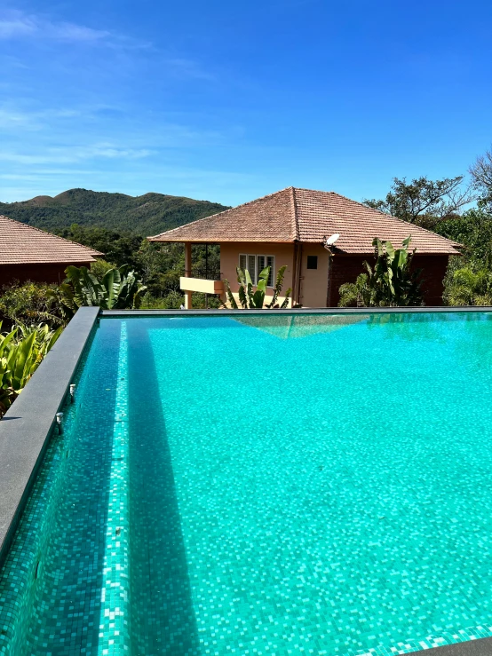 an empty swimming pool near some trees and a house