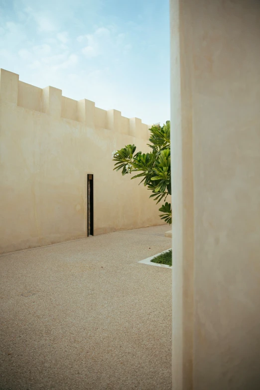 the back of a beige stucco wall with a black door