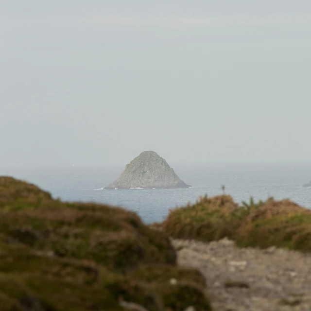 a rock outcropping with a small island behind it