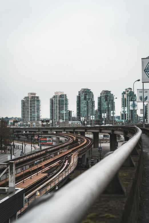 some cars on a train tracks near a big city