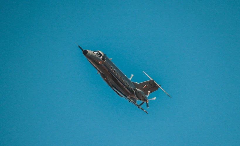 an aircraft flying through the clear blue sky