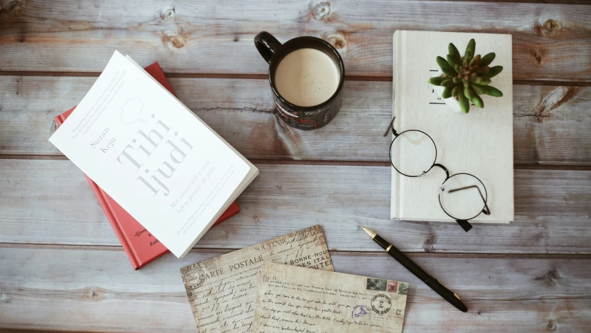 a note pad, pens and glasses sitting on top of papers